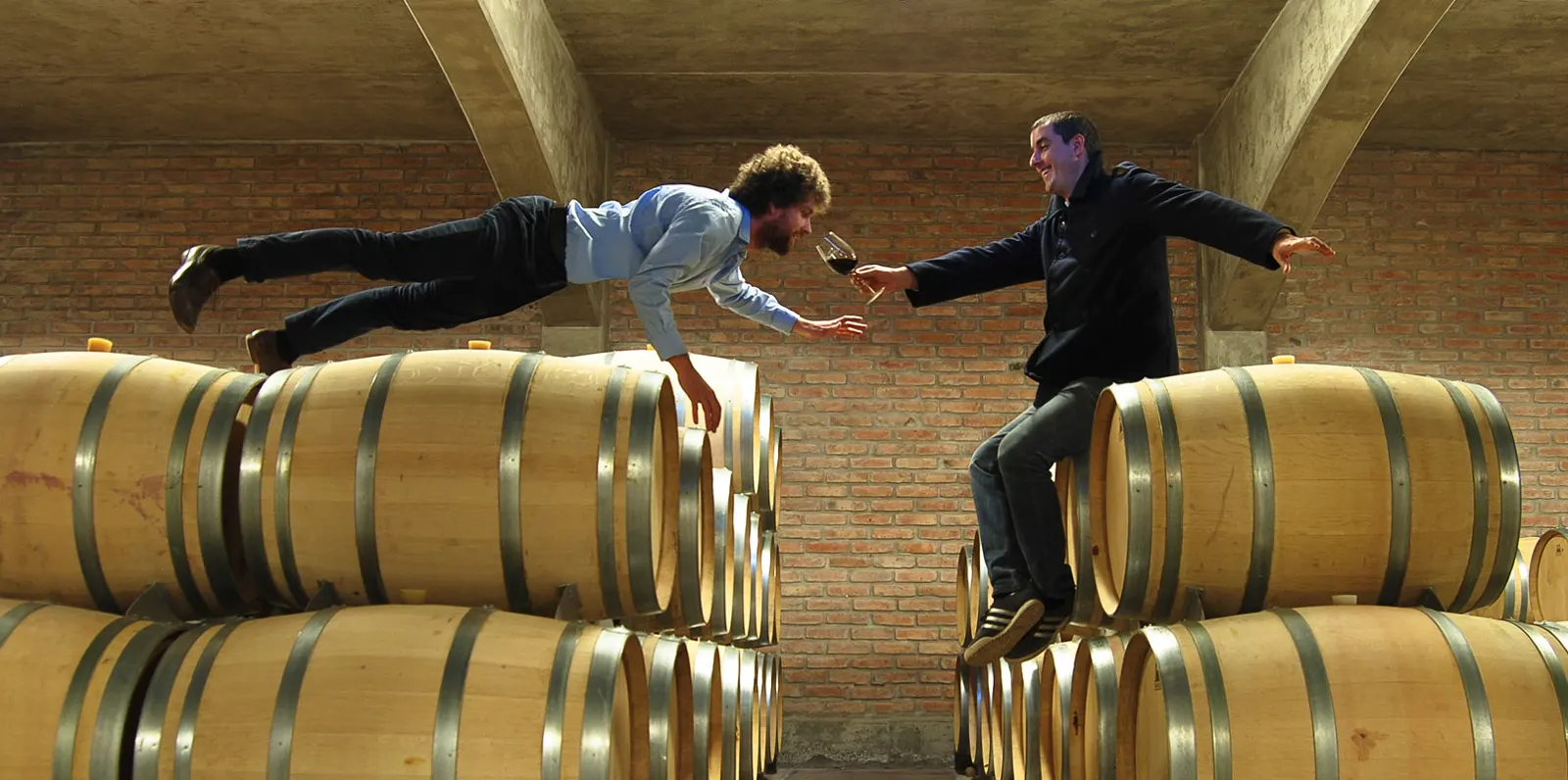 Les deux œnologues trinquant au-dessus des barriques de la bodega